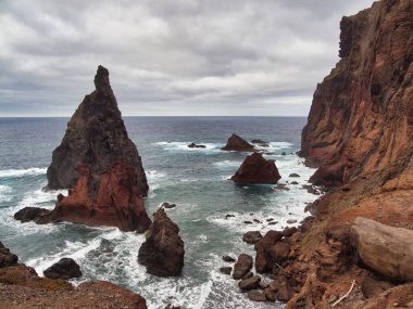 Madeira Deniz Yığını Üzerinde Altın Gün Batımı - Madeira 'daki Ilhus da Ribeira da Janela volkanik deniz yığınlarının gün batımında atmosferik manzarası, kayalık plaj ve Atlantik Okyanusu' nun üzerine düşen altın bir ışık.