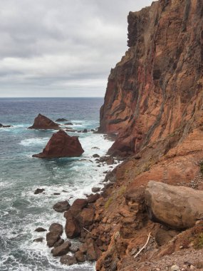 Madeira Deniz Yığını Üzerinde Altın Gün Batımı - Madeira 'daki Ilhus da Ribeira da Janela volkanik deniz yığınlarının gün batımında atmosferik manzarası, kayalık plaj ve Atlantik Okyanusu' nun üzerine düşen altın bir ışık.