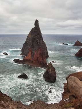 Madeira Deniz Yığını Üzerinde Altın Gün Batımı - Madeira 'daki Ilhus da Ribeira da Janela volkanik deniz yığınlarının gün batımında atmosferik manzarası, kayalık plaj ve Atlantik Okyanusu' nun üzerine düşen altın bir ışık.