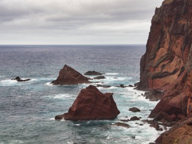 Madeira Deniz Yığını Üzerinde Altın Gün Batımı - Madeira 'daki Ilhus da Ribeira da Janela volkanik deniz yığınlarının gün batımında atmosferik manzarası, kayalık plaj ve Atlantik Okyanusu' nun üzerine düşen altın bir ışık.