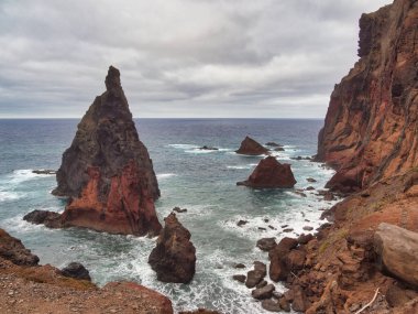 Madeira Deniz Yığını Üzerinde Altın Gün Batımı - Madeira 'daki Ilhus da Ribeira da Janela volkanik deniz yığınlarının gün batımında atmosferik manzarası, kayalık plaj ve Atlantik Okyanusu' nun üzerine düşen altın bir ışık.