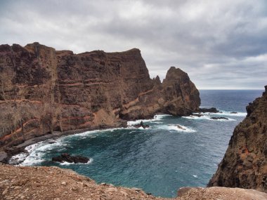 Madeira Deniz Yığını Üzerinde Altın Gün Batımı - Madeira 'daki Ilhus da Ribeira da Janela volkanik deniz yığınlarının gün batımında atmosferik manzarası, kayalık plaj ve Atlantik Okyanusu' nun üzerine düşen altın bir ışık.