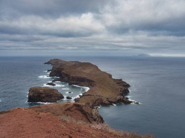 Madeira Deniz Yığını Üzerinde Altın Gün Batımı - Madeira 'daki Ilhus da Ribeira da Janela volkanik deniz yığınlarının gün batımında atmosferik manzarası, kayalık plaj ve Atlantik Okyanusu' nun üzerine düşen altın bir ışık.