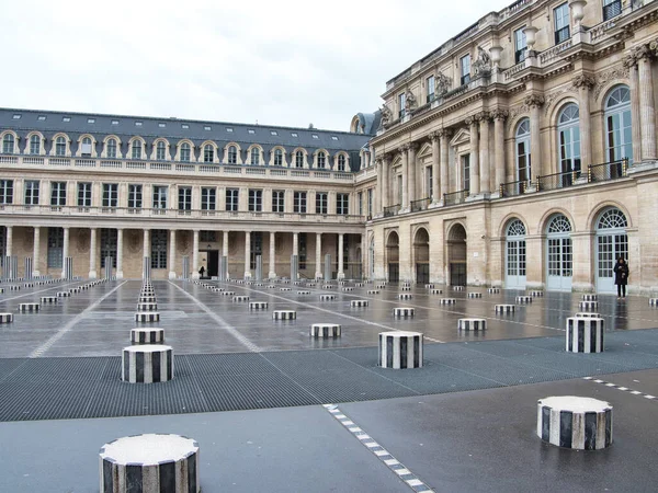 Palais Royal Cour d 'Honneur Les Colonnes de Buren - Tarihi Palais Royal avlusu ve Daniel Buren' in çizgili sütunları (Les Deux Plateaux) Paris 'te gri, bulutlu bir günde.