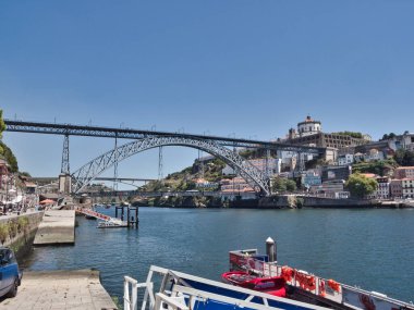 Dom Lus I Bridge ve Porto Skyline Sunset 'te - Douro Nehri' ni kaplayan ikonik metal kemer köprüsünün yüksek açılı görüntüsü, yayalar ve tarihi Porto silueti ve yumuşak akşam ışığında anıtlar.