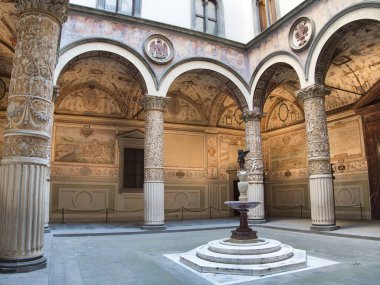 Floransa Rönesans Avlusu Fresco kemerleriyle süslenmiş sütunlar, merkezi bir çeşme ve Floransa sarayındaki güzel freskli kemerler ve duvarlarla dolu tarihi iç avlu..