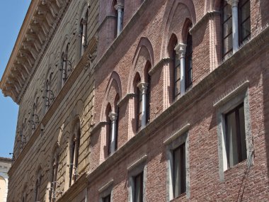 Tuscan Tuğla Cephesi - Çapraz görünüm tarihi bir binanın kırmızı tuğla cephesi ve Floransa, İtalya 'da beyaz sütunlu birden fazla kemerli penceresinin dokusunu gösteriyor.