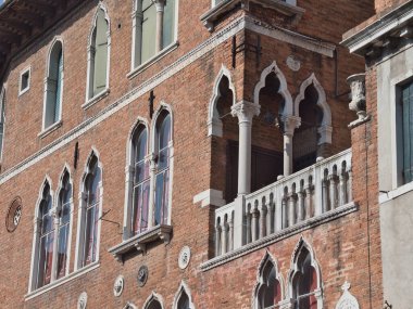 Karmaşık Venedik Gotik Pencereleri ve Balkon Detayları - Venedik 'in tarihi sarayına yakın plan görüntüsü Karmaşık Gotik kemerli pencereler, kırmızı tuğla ve detaylı bir taş balkon içeriyor.