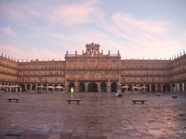 Şafak vakti Plaza Belediye Başkanı 'nın simetrik görüntüsü - Salamanca' da yumuşak bir pastel gökyüzünün altında tarihi kraliyet sarayı cephesi.