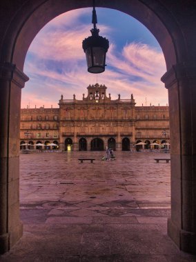 Salamanca 'nın Plaza Belediye Başkanı' nın Archway Manzarası - İspanyol meydanı, şafak vakti elinde fenerle karanlık bir kemer tarafından çerçevelendi.