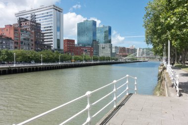 Bilbao Cityscape boyunca Nervin Nehri ve Zubizuri boyunca modern Isozaki kuleleri ve Zubizuri köprüsünün yer aldığı Bilbao silueti, İspanya 'daki Nervin Nehri boyunca uzanan manzaralı yürüyüş yolundan izlendi..