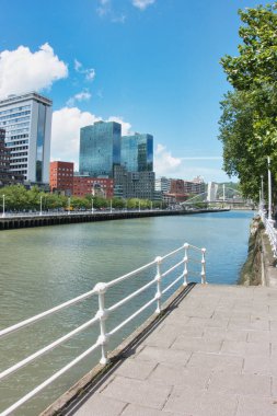 Bilbao Cityscape boyunca Nervin Nehri ve Zubizuri boyunca modern Isozaki kuleleri ve Zubizuri köprüsünün yer aldığı Bilbao silueti, İspanya 'daki Nervin Nehri boyunca uzanan manzaralı yürüyüş yolundan izlendi..