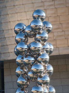 Guggenheim Müzesi Bilbao Küreleri Heykel Ayrıntıları - Guggenheim Müzesi Bilbao 'nun taş cephesine karşı çevrelenmiş, aynalı krom kürelerden oluşan bir heykel kümesinin yakın çekimi.