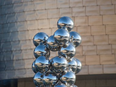 Guggenheim Müzesi Bilbao Küreleri Heykel Ayrıntıları - Guggenheim Müzesi Bilbao 'nun taş cephesine karşı çevrelenmiş, aynalı krom kürelerden oluşan bir heykel kümesinin yakın çekimi.
