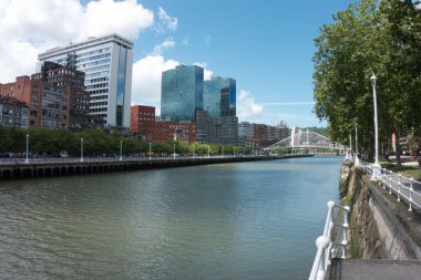 Bilbao Cityscape boyunca Nervin Nehri ve Zubizuri boyunca modern Isozaki kuleleri ve Zubizuri köprüsünün yer aldığı Bilbao silueti, İspanya 'daki Nervin Nehri boyunca uzanan manzaralı yürüyüş yolundan izlendi..