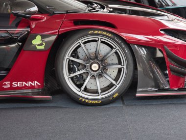 McLaren Senna Hypercar Wheel Detail - Pirelli lastiği, karbon seramik fren ve kırmızı bir süper arabanın karbon fiber aerodinamik gövdesi.