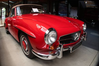 Klasik Red Roadster ve Tan Soft Top - Üstü açık klasik kırmızı bir Mercedes-Benz 'in düşük açılı çekimi yumuşak üstü açık, parlak krom ve bir galeride klasik tasarımı var..