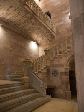 Tarihi Neo-Gotik Saray İç Merdiveni - Sobrellano Sarayı 'nın içinde süslü parmaklıkları olan taş merdiven ve balkonun dramatik alçak açılı görüntüsü.