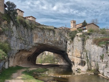 Doğal Kaya Kemeri 'ndeki Puentedey Köyü - İspanya' nın Burgos kentindeki Nela Nehri tarafından oyulmuş devasa doğal kaya köprüsünün tepesine ikonik taş köy inşa edildi.