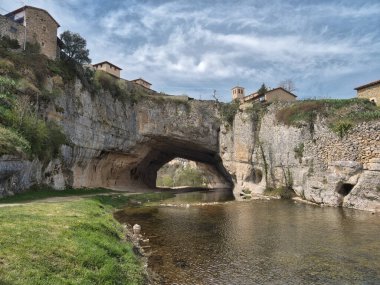Doğal Kaya Kemeri 'ndeki Puentedey Köyü - İspanya' nın Burgos kentindeki Nela Nehri tarafından oyulmuş devasa doğal kaya köprüsünün tepesine ikonik taş köy inşa edildi.