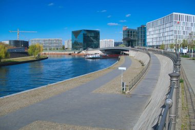 Berlin 'in Modern Spree Nehri Rıhtımı - Berlin, Almanya' da Spree boyunca sahnelenen nehir kenarı açık güneşli bir günde hükümet bölgesinin çağdaş mimarisi.