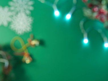 Şenlikli Tatil Yeşil Bokeh Arkaplanı - Şenlikli ışıklar, kar taneleri ve süslerle bulanık yeşil arka plan, Noel ve kış tasarımları için büyülü bir atmosfer yaratıyor.