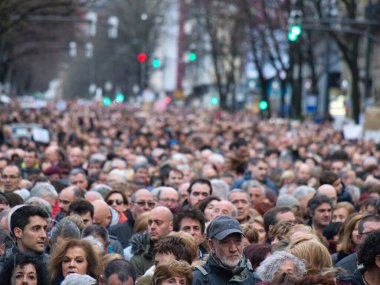 Bilbao, Pas Vasco, İspanya, 17 Mart 2018, kalabalık bir kalabalık kalabalık büyük bir halk gösterisi ya da protesto yürüyüşü sırasında geniş bir şehir caddesini dolduruyor. Katılımcıların farklı yüzlerine odaklan.