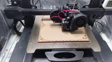3D Yazıcı Ek Üretim Sürecini kapat; Birleşmiş Mevduat Modellemesinin (FDM) 3D yazıcı nozulasının detaylı yakın çekim görüntüsü açık kahverengi filament ekstrüksiyonu, kompleks bir konteynır katmanı oluşturma 