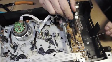 PCB 'deki lehimleme bileşenleri - Teknisyenin elleri modern bir tüketici cihazını tamir etmek için lehimleme demiriyle elektronik devre kartını tamir ediyor.