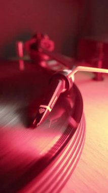 Turntable Cartridge üzerinde dönen Vinil Record; Bir Ortofon Concorde kartuşunun yakın plan dikey çekimi, bir turntable üzerinde hızla dönen siyah bir vinil plağı takip ediyor. Klasik müzik ve ses aygıtı.