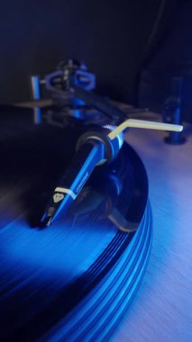 Turntable Cartridge üzerinde dönen Vinil Record; Bir Ortofon Concorde kartuşunun yakın plan dikey çekimi, bir turntable üzerinde hızla dönen siyah bir vinil plağı takip ediyor. Klasik müzik ve ses aygıtı.