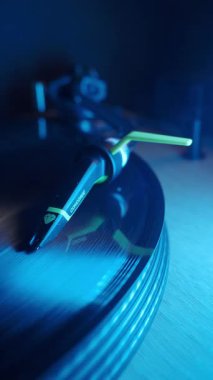 Turntable Cartridge üzerinde dönen Vinil Record; Bir Ortofon Concorde kartuşunun yakın plan dikey çekimi, bir turntable üzerinde hızla dönen siyah bir vinil plağı takip ediyor. Klasik müzik ve ses aygıtı.