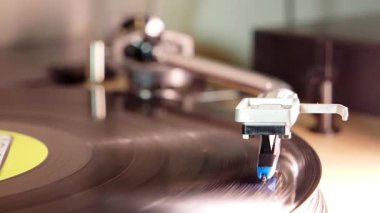 RGB Parti Işıklandırması ile dönen Vinil Plağı; Plak platformunda dönen siyah plağı takip eden bir stilin aşırı yakın çekimi. Dinamik RGB renk ışıklandırması ritimle senkronize olarak değişir.