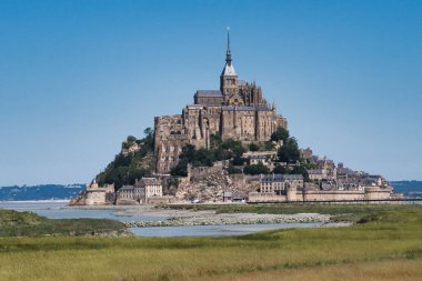 Oda - Normandiya - Fransa 16 Temmuz 2025, Fransa Loire Vadisi 'ndeki ikonik Chateau de Chambord' un panoramik manzarası. Ünlü Fransız Rönesans mimarisi bir tarla ve kasvetli, bulutlu gökyüzü tarafından çerçevelenmiştir..