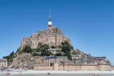 Mont Saint-Michel Abbey ve Tidal Island, Fransa; Mont Saint-Michel adası komünü ve Gotik Benedikt Manastırı 'nın güneşli bir günde Normandiya, Fransa' daki gelgit düzlüklerinden yükselişi.