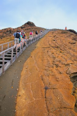GALAPAGOS, ECUADOR - APRIL 20: Unidentified people hike to viewpoint on April 20, 2015 on Bartolome island in Galapagos National Park, Ecuador. This park is a UNESCO World Heritage Site clipart