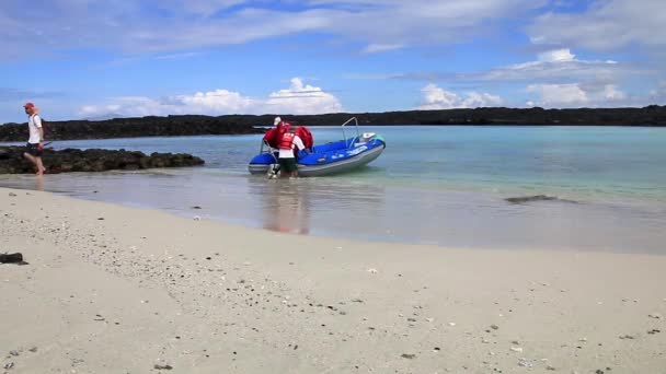 GALAPAGOS, EQUADOR - 20 DE ABRIL: Homem não identificado descarrega coletes salva-vidas na praia da ilha do Chapéu Chinês em 20 de abril de 2015 em Galápagos, Equador. Parque Nacional de Galápagos é Patrimônio Mundial da UNESCO — Vídeo de Stock