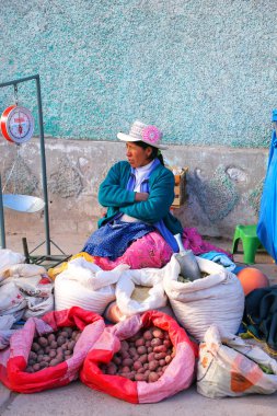Chivay, Peru-15 Ocak: Kimliği belirsiz kadın Ocak'ta sokak pazarında patates ve tahıl satıyor 15, 2015 Chivay, Peru. Chivay, Caylloma eyaletinin başkentidir..