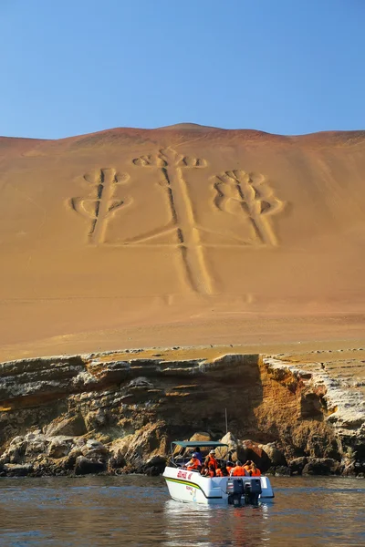 Paracas, peru-januar 26: Unbekannte betrachten Kandelaber der Anden von einem Boot aus am 26. januar 2015 in der bucht von pisco, peru. Kandelaber ist eine bekannte prähistorische Geoglyphe, die auf der Nordseite der Paracas-Halbinsel gefunden wurde — Stockfoto