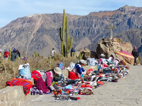 COLCA, PERÚ-ENERO 16: Mujeres no identificadas venden souvenirs el 16 de enero de 2015 en Mirador Cruz del Cóndor en el Cañón del Colca, Perú. Es un punto de vista muy popular para detectar cóndores andinos . — Foto de Stock