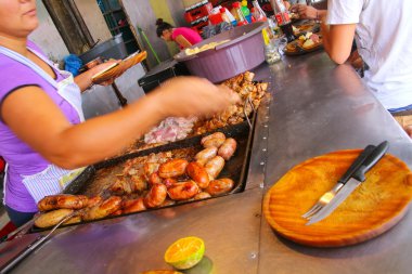 ASUNCION, PARAGUAY-DECEMBER 26: Unidentified woman cooks meat fo clipart
