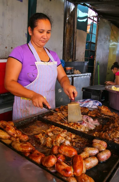 ASUNCION, PARAGUAY-DICIEMBRE 26: Mujer no identificada cocina carne — Foto de Stock