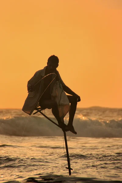 Silhuetten av en pinne fiskare vid solnedgången, unawatuna, sri lanka — Stockfoto
