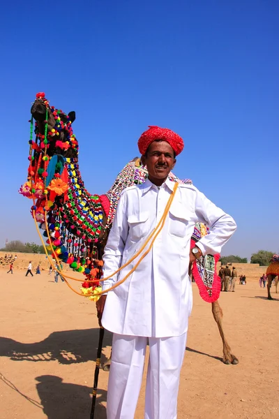 Indian man standing with his decorated camel at Desert Festival, — Stock Photo, Image