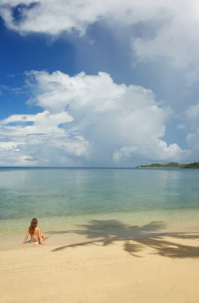 Ung kvinna i bikini sitter på en tropisk strand, Nananu-i-Ra jag — Stockfoto