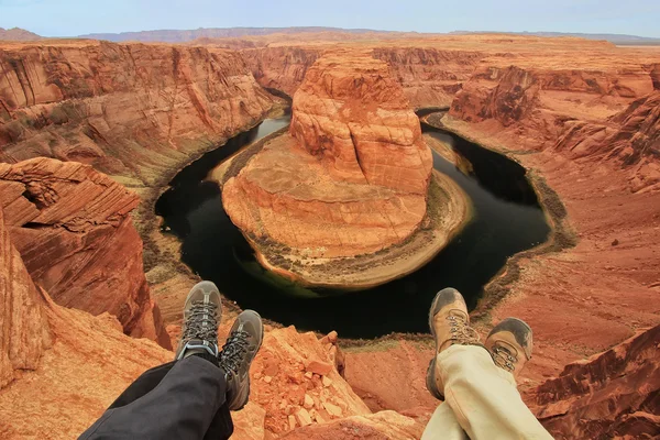 Deux paires de jambes au Horseshoe bend surplombent, concept d'aventure — Photo