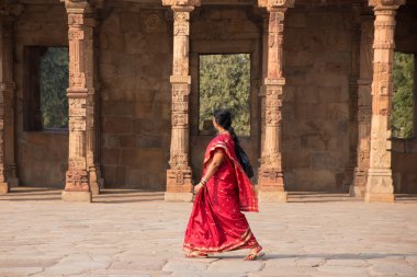 Delhi, Hindistan - 4 Kasım: Kimliği belirsiz kadın Kasım'da Qutub Minar kompleksinde Quwwat-Ul-Islam cami avluda yürüyor 4, 2014 Delhi, Hindistan. Qutub Minar Hindistan'ın en uzun minar olduğunu