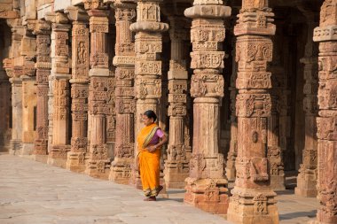 Delhi, Hindistan - 4 Kasım: Kimliği belirsiz kadın Kasım'da Qutub Minar kompleksinde Quwwat-Ul-Islam cami avluda yürüyor 4, 2014 Delhi, Hindistan. Qutub Minar Indiae en yüksek minar olduğunu