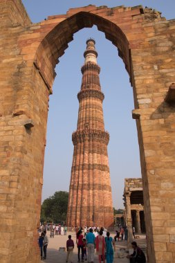 Qutub Minar Delhi, Hindistan karmaşık etrafta yürüyen turist