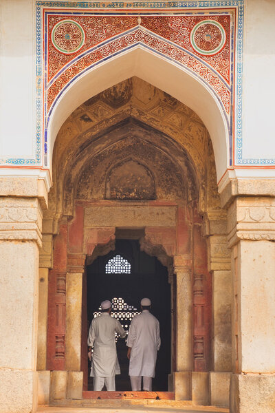 Men in white dresses standing at Isa Khan Niyazi tomb entrance, 